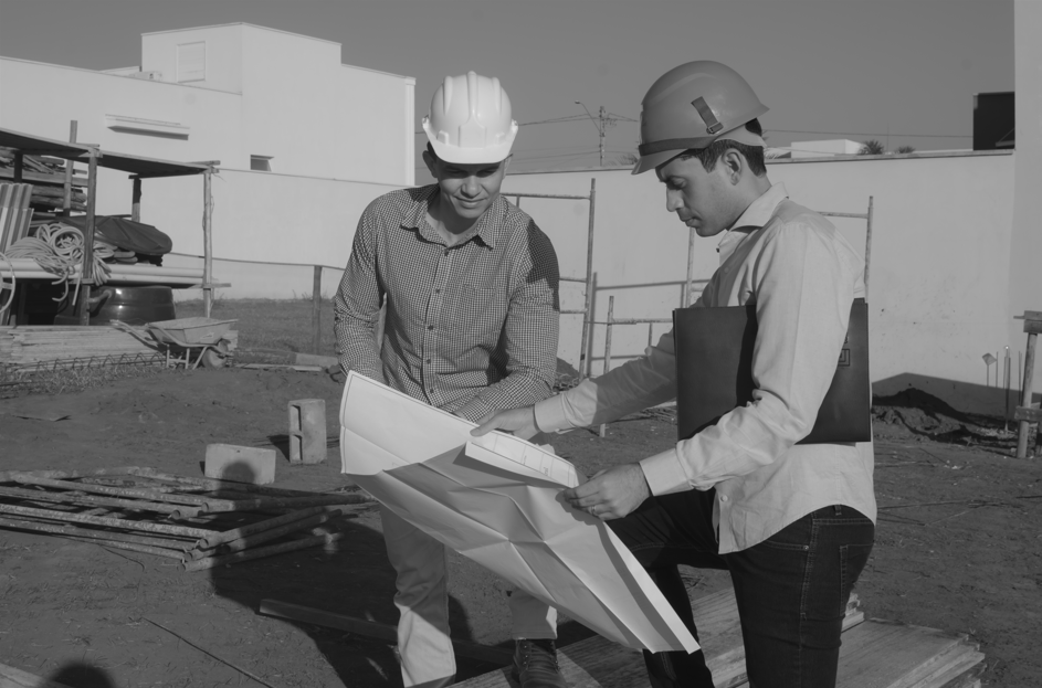 Engenheiros da LU Engenharia conferindo plantas em canteiro de obras, representando a vistoria técnica de recebimento de casa