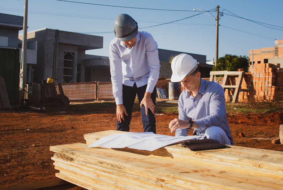 Engenheiros da LU Engenharia analisando plantas do projeto estrutural em canteiro de obras